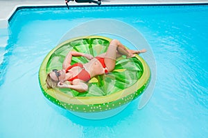 Girl lying on inflatable in swimming pool