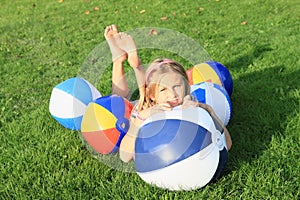 Girl lying among inflating balls