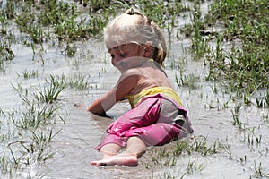 Girl lying in muddy water