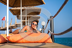 Girl lying on the pier. Attractive young woman in swimsuit lying on the pier. woman in swimsuit lying on the wooden pier on the