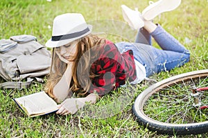 Girl lying and reading book on grass