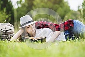 Girl lying and reading book on grass