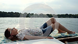 Girl lying on Sail Boat yacht enjoys the sea on a big ship while sailing on sea.