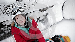 Girl is lying on the snow with a snowboard board