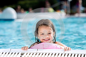 Girl lying in swimming pool. Summer heat and water.