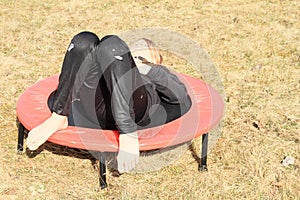 Girl lying on trampoline