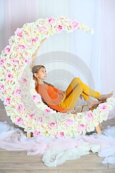 Girl lying on a wooden lounger in the form of moon photo