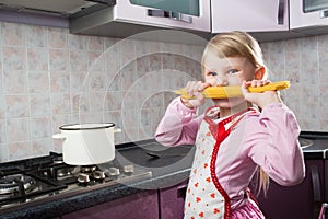 Girl with macaroni in the kitchen