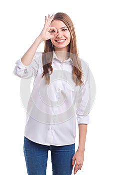 The girl made a circle with her fingers and looks at the skull on a white isolated background