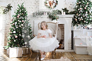 Girl with magic wands sitting in chair. Christmas