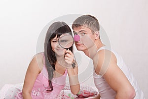 Girl with magnifying glass, guy clown nose