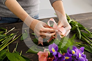 Girl make bouquet over gray background.