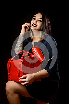 Girl make-up artist in dark dress with red suitcase and accessorized make-up artist