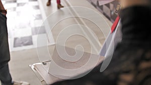 The girl makes adjustments with a ballpoint pen on the sheets with notes. The sheets are fixed on the tablet. Organization of acti