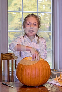 Girl makes a face as she touches slimy pumpkin