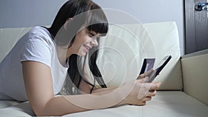Girl makes online sale shopping concept with digital tablet. brunette lying on lifestyle the couch watching shop online