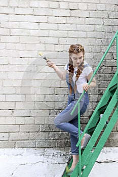 The girl makes preparing for painting a wooden surface gazebo, fence photo