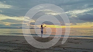 Girl Makes Selfie on Beach against Golden Sunrise above Ocean