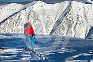 Girl makes ski mountaineering alone toward the mountain pass in a nice track with sealskin