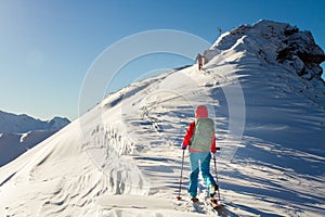 Girl makes ski mountaineering alone toward the mountain pass in a nice track with sealskin