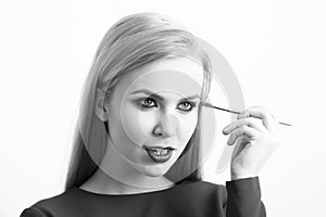 Girl with makeup brush applying eye shadow