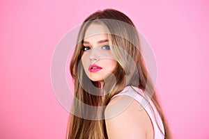 Girl with makeup and healthy hair. Fashion look concept. woman with long hair on pink background. Beauty and