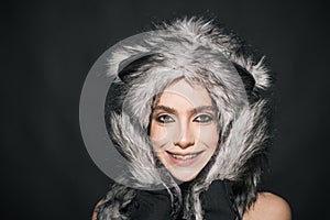 Girl with makeup wears fluffy fur hat with ears like cat. Cute kitty outfit. Carnival and Halloween ideas. Cute outfit