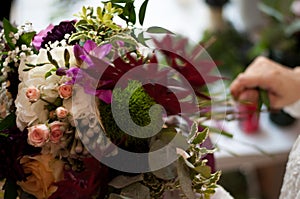 Girl Making a Beautiful Wedding Flower Bouquet of Purple Roses