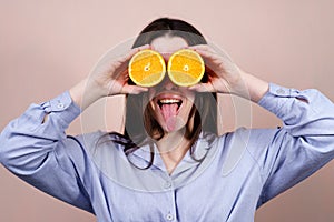 Girl making binoculars with two pieces of orange