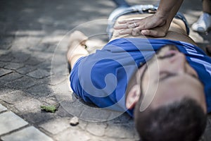 Girl making cardiopulmonary resuscitation to an unconscious guy after heart attack