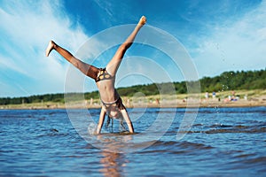 Girl making cartwheel in the water photo