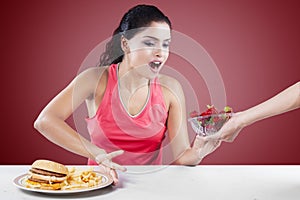 Girl Making Choice Between Burger And Strawberry