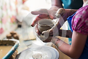 Girl making a clay bowl on sculpting wheel