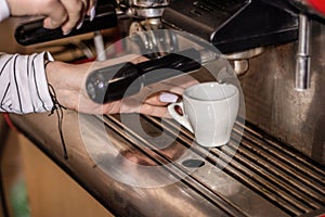 Girl making espresso coffee on a professional machine in the bar