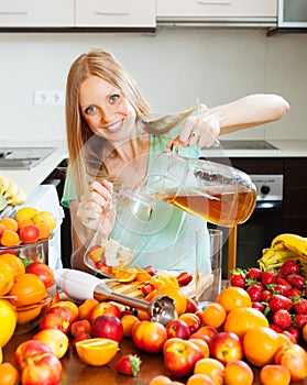 Girl making fresh beverages with fruits at home kitchen