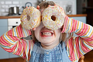 Girl Making Glasses Using Sugary Doughnuts photo