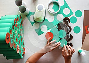 Girl making handmade advent calendar with toilet paper rolls at home. Seasonal activity for kids