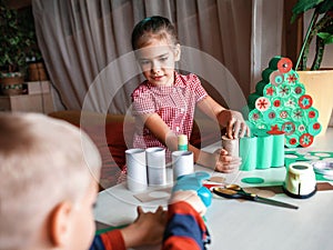 Girl making handmade advent calendar with toilet paper rolls at home. Seasonal activity for kids