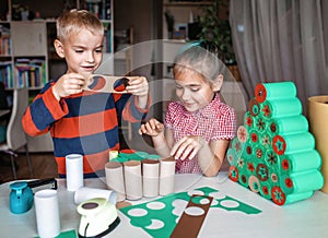 Girl making handmade advent calendar with toilet paper rolls at home. Seasonal activity for kids