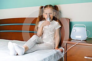 Girl making inhalation with nebulizer at home