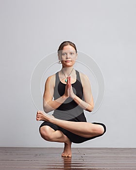 Girl making one foot balance yoga pose.
