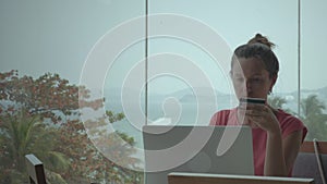 Girl Making Online Purchases In Hall With Big Windows