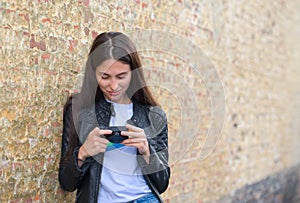 Girl making photo of historical building with camera on city street