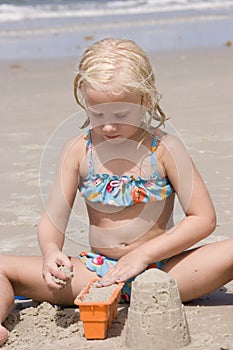 Girl Making Sand Castles at Beach