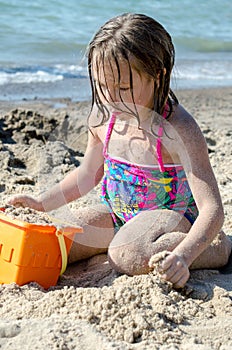 Girl making sand castles on beach