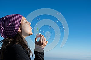Girl making soap bubbles in the blue sky