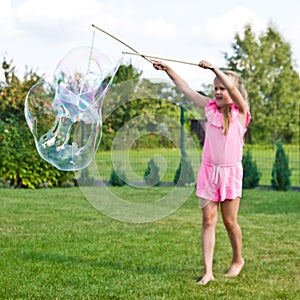 Girl making soap bubbles in home garden