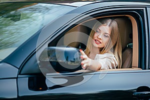 Girl making up into a car.