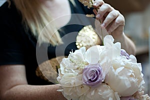 Girl Making a Wedding Flower Bouquet with White Hydrangea, Peonies and Purple Roses