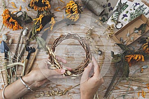 Girl making wreath in oats spikelets. Dried herbs and dried flowers for making herbarium